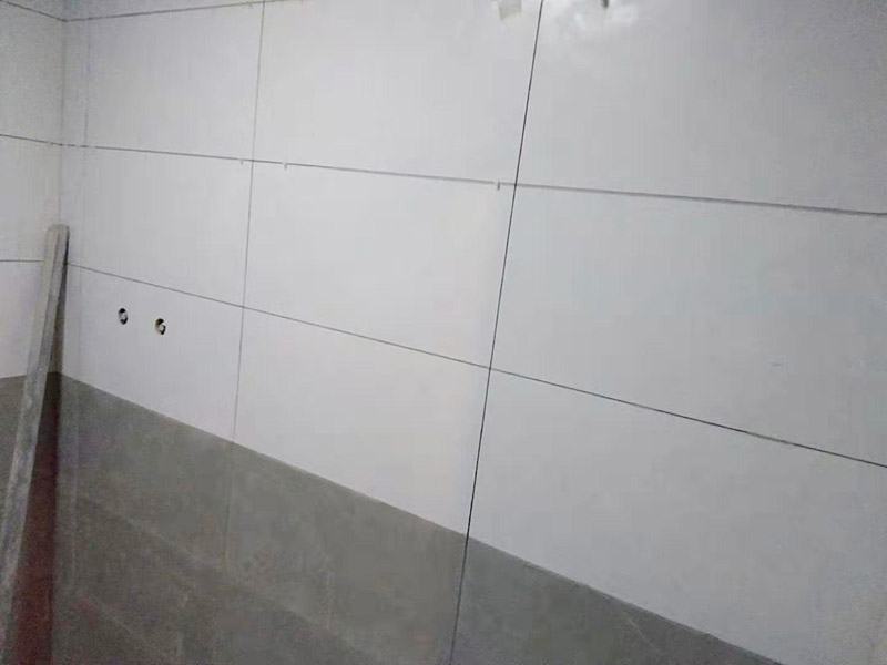 浴室墻面貼瓷磚：貼瓷磚之前先要用水浸泡瓷磚2小時(shí)左右。泡水的目的是為了讓瓷磚能事先吸飽水分，避免鋪貼之后吸走粘接材料中的水分，從而影響粘接的強(qiáng)度，浸水后記得用棉布擦去表面的水分晾干后才能進(jìn)行鋪貼。鋪貼開(kāi)始前還應(yīng)吊垂線，來(lái)確定瓷磚的尺寸線，然后開(kāi)始貼瓷磚，一般都是從門(mén)窗先開(kāi)始，而且按由下而上，自左至右的順序進(jìn)行。鋪貼的方法是先用水潤(rùn)濕找平層，然后用鏟子將事先拌好的粘接材料抹在瓷磚背面，再將瓷磚貼在墻上即可，依次鋪貼平整就可以了。